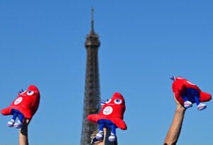 Trois peluches des Phryges brandies devant la Tour Eiffel