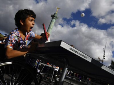 Un enfant essayant le Tennis de table fauteuil