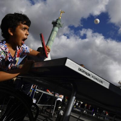 Un enfant essayant le Tennis de table fauteuil