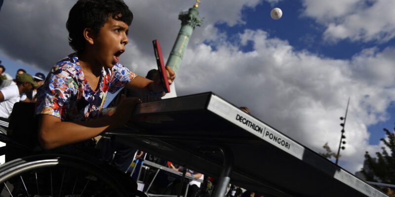 Un enfant essayant le Tennis de table fauteuil